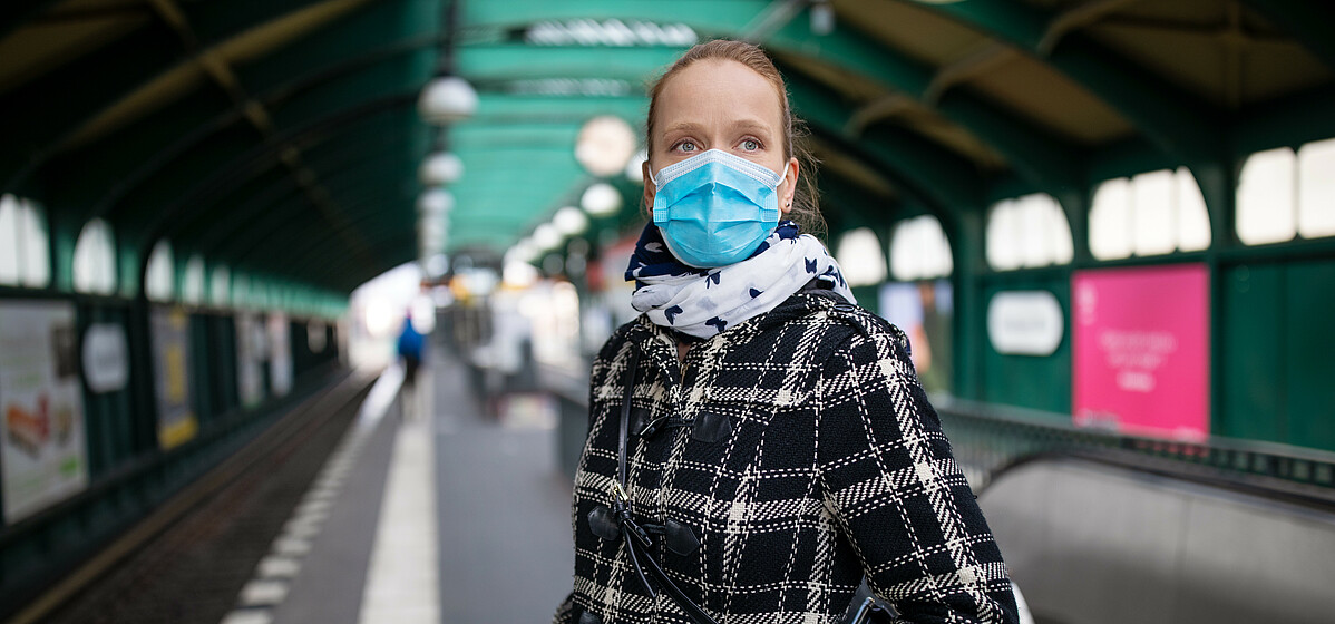 Woman wearing mask waiting for the city train at an almost empty Berlin station